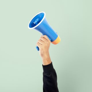 Hand holding megaphone marketing announcement campaign